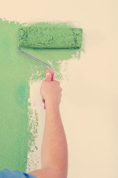 handsome young man paint white wall in color